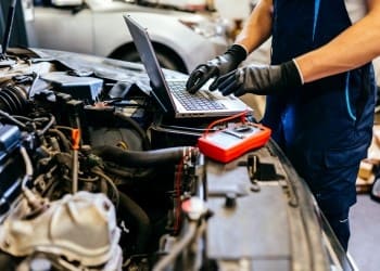 ASE-certified mechanic running a mobile diagnostic with a laptop scanner — Allied Auto Services